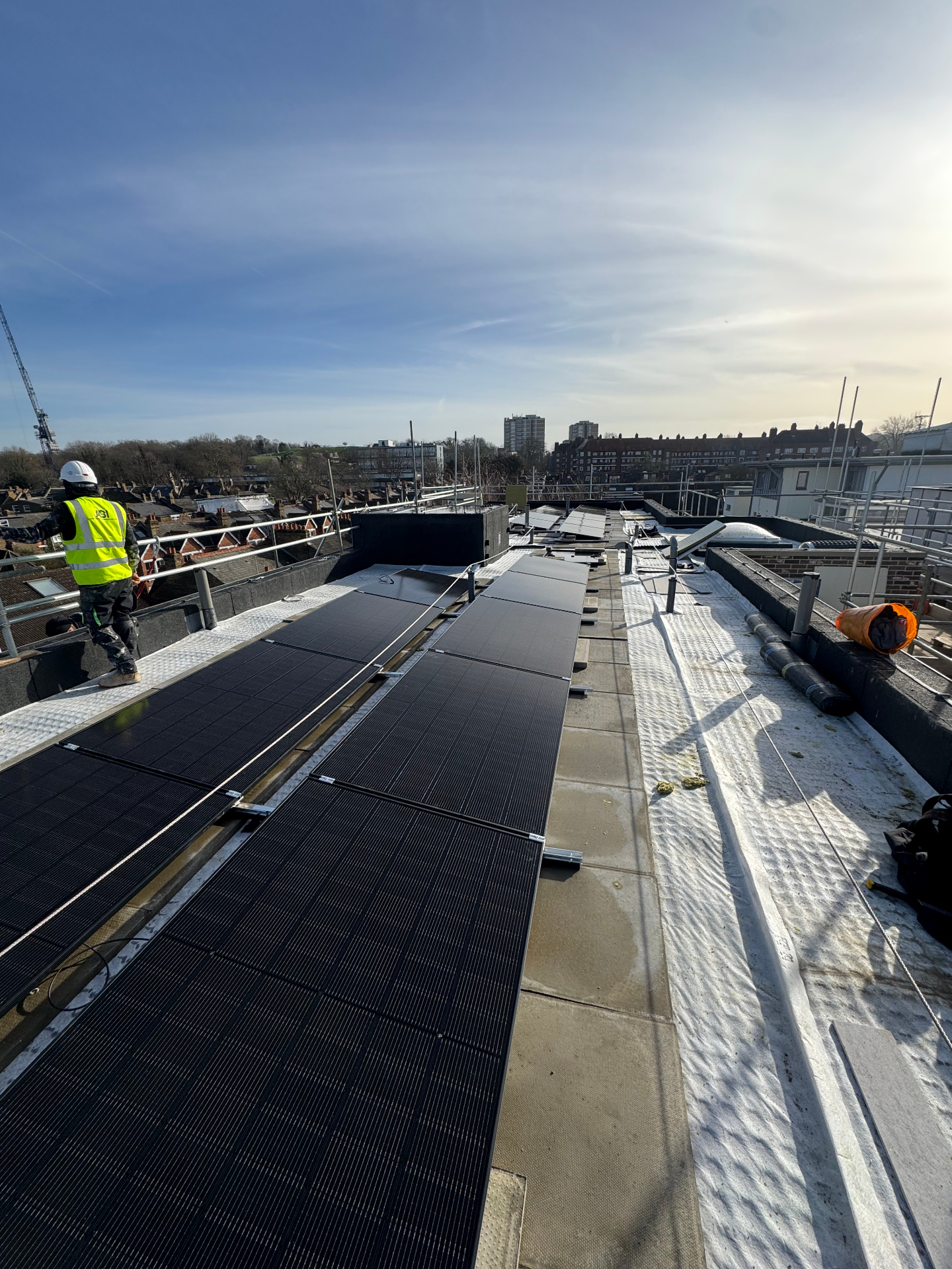 All-black panel array on flat roof with rooftop walkway access. — solar PV installation in Peckham Rye by Solid Electrical